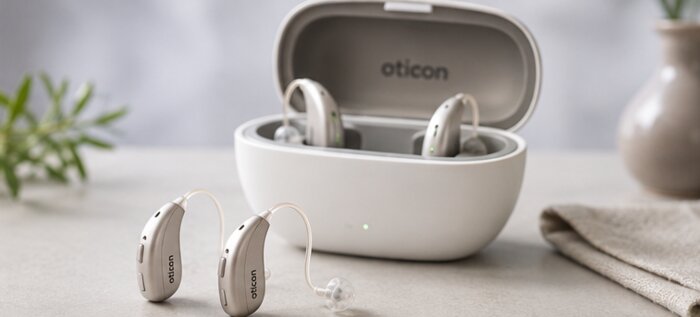 Oticon hearing aids resting in their charging case